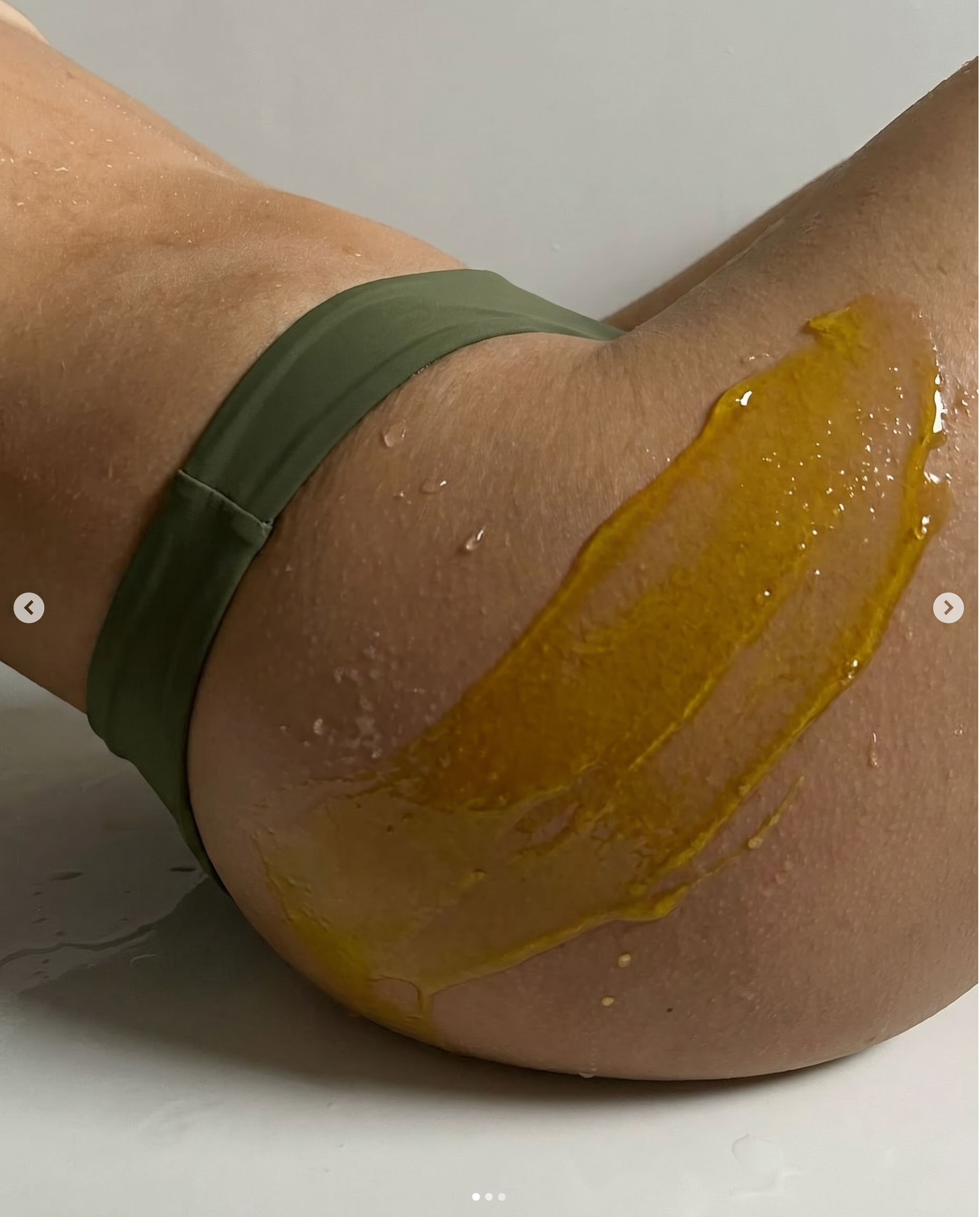 A girl in a bikini is posing with Phyto Pure oil dripping down her leg. 